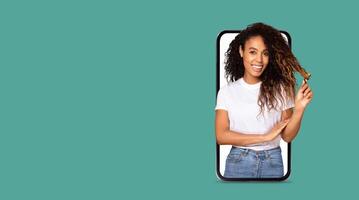 A joyful individual interacts with a smartphone featuring a large screen, showcasing online communication. The background is vibrant, offering ample space for text or graphics. photo