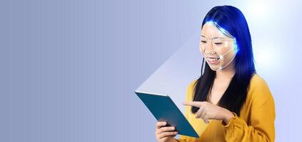 A young woman interacts with a tablet using facial recognition technology. The device scans her face while she smiles, showcasing advancements in modern ID systems. The background remains simple. photo