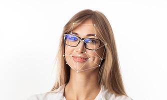 A woman with glasses smiles while facial recognition technology overlays geometric patterns on her face. This illustrates advancements in identification methods and digital applications. photo