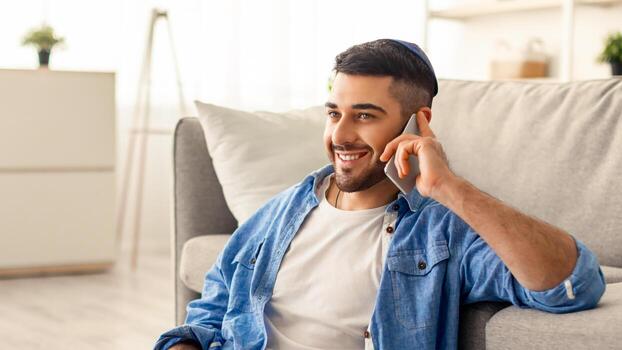 teletrabajo joven sonriente empresario hablando en Teléfono móvil utilizando ordenador portátil a hogar lugar de trabajo, sentado en piso. acuerdo discusión con socios, planificación futuro reuniones, cliente consultante concepto foto