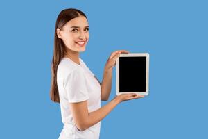 Cool Application Concept. Smiling woman holding tablet, showing black blank screen, empty space, mock up photo