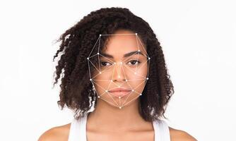 A young individual showing a neutral expression as facial recognition technology analyzes their face. The background is plain, emphasizing the technology's detailed overlay on their features. photo