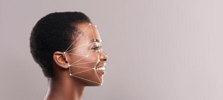 A joyful person with short hair is captured in profile, highlighting facial recognition technology with lines mapping facial features. The background is minimalistic, enhancing focus on the subject. photo
