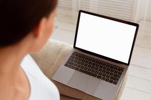 Unrecognizable Woman Looking At Laptop Empty Screen Browsing Internet Sitting At Home. Mockup, Selective Focus photo