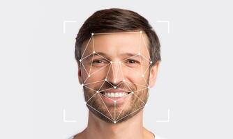 A smiling man is being analyzed by facial recognition technology. Geometric lines connect points on his face, indicating identification procedure. photo