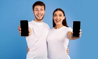 Useful Application Or Website. Excited couple showing black blank cellphone screen, empty space, mock up photo