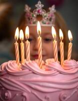 Celebration of a birthday with a pink cake and lit candles surrounded by cheerful atmosphere photo