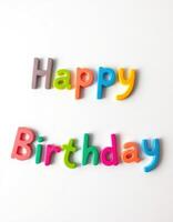 Colorful letters spelling happy birthday on a white background creating a festive atmosphere for celebration photo