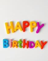 Colorful plastic letters spell happy birthday on a white surface with a playful and festive atmosphere photo