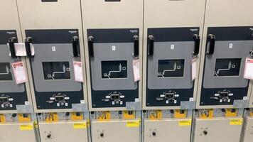 Rows of Electrical Switchgear Panels with Safety Labels in a Power Distribution Facility photo