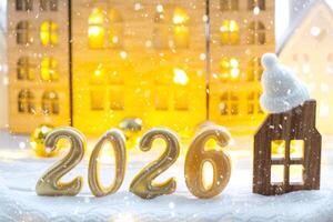 Golden number 2026 and tiny home background of cozy windows of a house with warm light with festive decor of stars,snow and garlands. Greeting card, Happy New Year, cozy home photo
