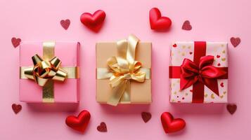 Three beautifully wrapped gift boxes are arranged on a soft pink surface, adorned with gold bows. Cute red hearts scattered around create romantic Valentines Day photo