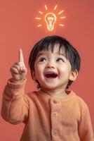 A child is smiling and pointing up at an idea light bulb photo