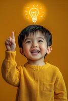 A young boy is holding up an idea light bulb photo