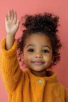 A little girl with curly hair waving her hand photo