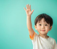 Asian boy raising his hand in the air photo
