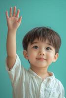 Asian boy raising his hand in the air photo
