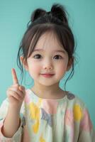 A little girl with her finger up in the air photo