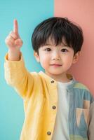 Asian boy pointing finger up on colorful background photo