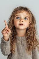 A little girl pointing her finger up photo