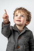 A young boy in a coat pointing up photo