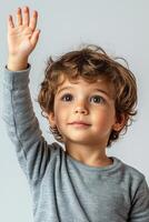 A young boy with his hand up in the air photo