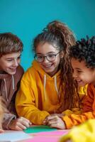 Group of children sitting at table with paper and pencils photo
