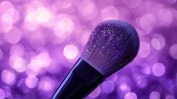 A makeup brush with glitter on the bristles, set against a purple bokeh background. photo