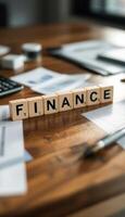 Finance concept with wooden blocks on a desk surrounded by papers and a calculator photo