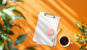 Bright Workspace Setup with Clipboard and Coffee on Orange Backdrop photo