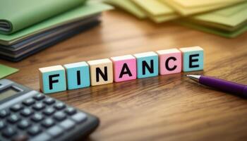 Finance spelled out in colorful blocks with calculator, pen and folders on wood desk photo