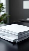 Stack of Blank White Books Ready for Notes or Publication on a Black Table photo