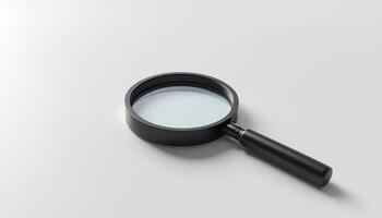 A Black Framed Magnifying Glass Tool Lying Flat on a White Surface for Study or Research photo