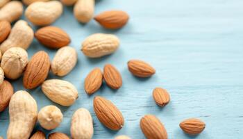 Assorted Almonds and Peanuts on a Light Blue Textured Background Top View photo