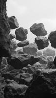 Monochromatic ballet of levitating rocks amidst a surreal hazy atmosphere photo