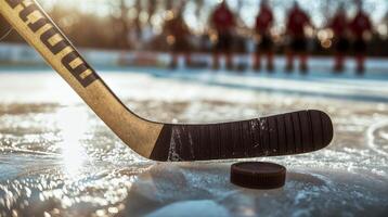 Hockey stick and puck on ice rink with players in background photo