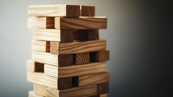 Wooden blocks tower balancing on gray background symbolizing risk and strategy photo