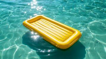 Yellow inflatable mattress floating on sparkling turquoise water photo