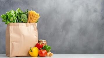 grocery items in paper bag on white table gray wall. food with fresh vegetable canned goods copy space for your text photo