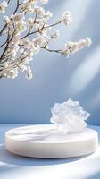 white podium mockup displaying acrylic stone, sakura branches spring casting delicate shadows on serene blue background photo