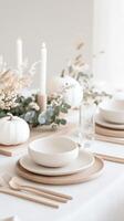 Minimalist autumn table setting with white pumpkins, candles, and eucalyptus leaves cozy atmosphere Minimalist Thanksgiving photo