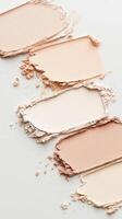 Foundation samples blending across white surface, displaying gradient makeup palette for cosmetic compact powder design photo