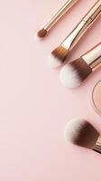 Makeup brushes, lipstick, highlighter, and blush scattered artfully on soft pink surface, representing modern beauty product arrangement Copy space for text photo
