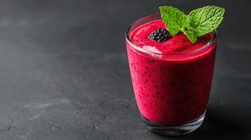Delicious and creamy blackberry smoothie garnished with fresh mint offering a refreshing and gray background healthy eating preparation for menu, recipe and food blog copy space photo