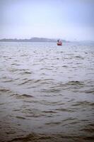 A red fishermans boat in the sea and seagulls flying round it. Lomma, Sweden, 2025 photo