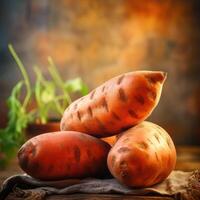 A photograph of three whole sweet potatoes, with one on top resting on a second potato and another sitting beneath. photo