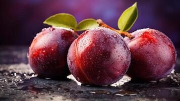 Three red peaches with water droplets on them, set against a dark background photo