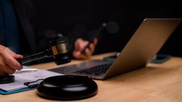 Judges gavel is poised over sleek workspace, intersection of traditional justice and modern technology, highlighting how digital tools support legal proceedings in todays world photo