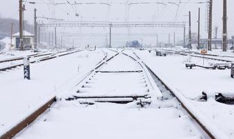 Snowfall covers a railway station with many tracks with fluffy snow. photo