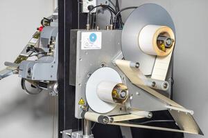 The self-adhesive label applicator is a very simple and convenient device. photo